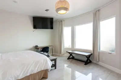 a bedroom with a bed and a desk and a television at Spacious 5 BR Brand New House LAX in Inglewood