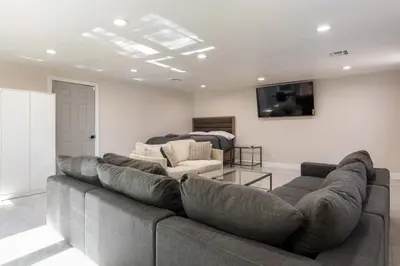 a living room with a large couch and a tv at Spacious 5 BR Brand New House LAX in Inglewood