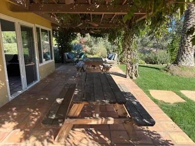 a patio with a wooden table and a bench at Paradise at Tree Ranch Grove in Ojai