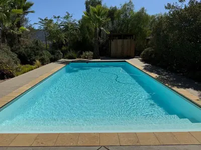 a swimming pool with blue water in a yard at Paradise at Tree Ranch Grove in Ojai