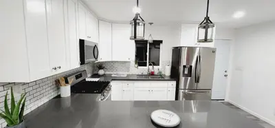 a kitchen with white cabinets and a stainless steel refrigerator at Cozy Home Away From Home in Northridge Hospital Heliport