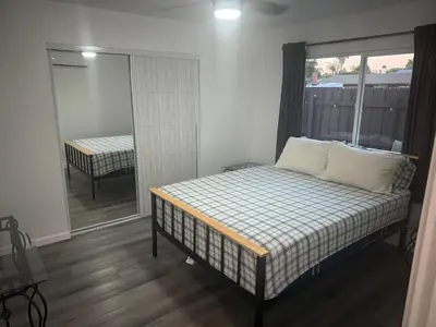 a bedroom with a bed and a sliding glass door at Cozy Home Away From Home in Northridge Hospital Heliport