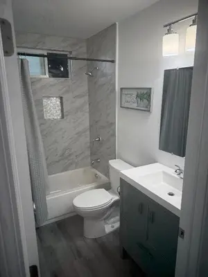 a bathroom with a toilet and a tub and a sink at Cozy Home Away From Home in Northridge Hospital Heliport