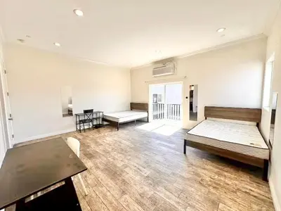 a large room with two beds and tables in it at Lovely 3-bedroom house with AC in vibrant Los Angeles Near USC in Los Angeles