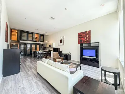 a living room with a white couch and a tv at Stylish 2BR Loft with Top-Tier Amenities - 104 - GL in Glendale