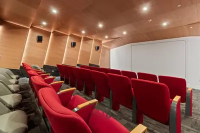 a lecture room with red chairs and a screen at Stylish 2BR Loft with Top-Tier Amenities - 104 - GL in Glendale