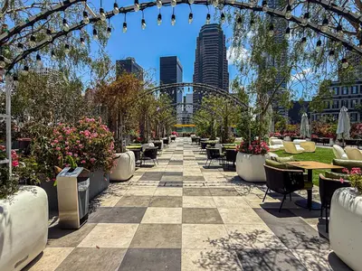 a patio with tables and chairs and flowers in a city at Cozy 2BR Loft in a Vibrant Complex - 107 - GL in Glendale