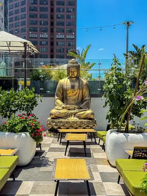 a large statue of a buddha sitting on a patio at Cozy 2BR Loft in a Vibrant Complex - 107 - GL in Glendale