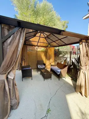 a covered patio with chairs and a couch and tables at 3-Bedroom Luxury Villa Near Dodger Stadium, Downtown LA Free Parking in Los Angeles