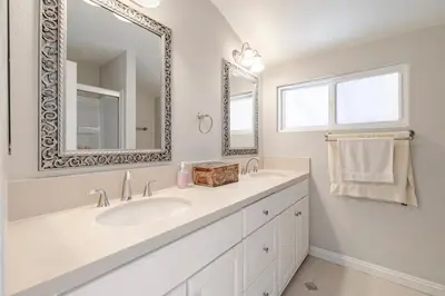 a white bathroom with a sink and a mirror at Spacious 4-bedroom family house-20 mins to Disney Land in Rowland Heights