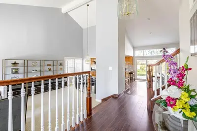 a staircase in a house with a vase of flowers at Spacious 4-bedroom family house-20 mins to Disney Land in Rowland Heights