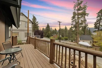 a wooden deck with a table and chairs on it at Lakeview Pines Log Cabin - Custom Built Village Log Cabin Retreat w/ Hot Tub, Pool Table in Big Bear Lake