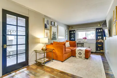 a living room with an orange couch and a window at Hike, Ski, Relax Mtn Getaway in Lake Arrowhead in Lake Arrowhead