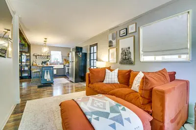 a living room with an orange couch and a kitchen at Hike, Ski, Relax Mtn Getaway in Lake Arrowhead in Lake Arrowhead