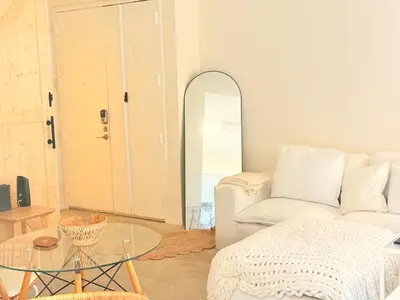 a living room with a white couch and a glass table at Luxury stay by Gaia Homes in Los Angeles