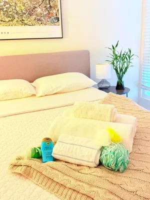 a bed with two towels and a bottle on it at Luxury stay by Gaia Homes in Los Angeles