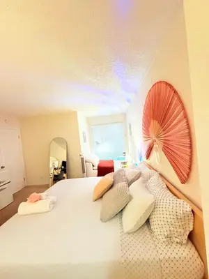a bedroom with a large white bed with a fan on the wall at Luxury stay by Gaia Homes in Los Angeles