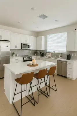 a kitchen with a white counter and two chairs at \u4e09\u697c\u4e24\u623f\u4e24\u536b\u8fd1\u5e02\u4e2d\u5fc3\u4ea4\u901a\u4fbf\u5229\u6b65\u884c\u53ef\u8fbe\u5546\u5708\u9002\u5408\u5bb6\u5ead in Eastvale