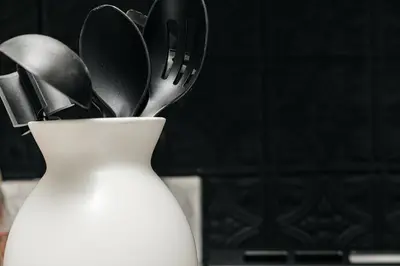 a white vase with knives and utensils in it at Ocean Breeze Retreat in Los Angeles