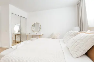 a white bedroom with a white bed and two mirrors at Ocean Breeze Retreat in Los Angeles