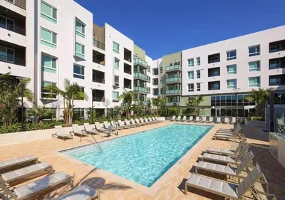 a swimming pool with lounge chairs and a building at Luxury Stay Near Disneyland With Pool Gym & Free Parking in Santa Ana
