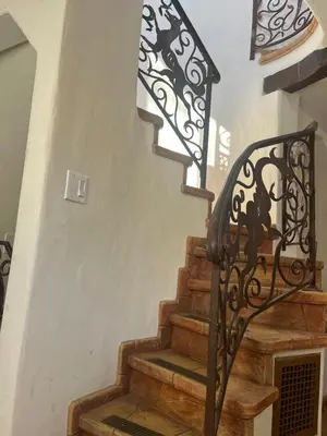 a staircase with a wrought iron railing and wooden steps at The Magic castle Unit 1-2 in Santa Clarita
