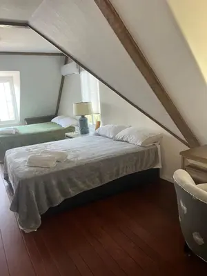 a bedroom with a bed and a chair in a attic at The Magic castle Unit 1-2 in Santa Clarita