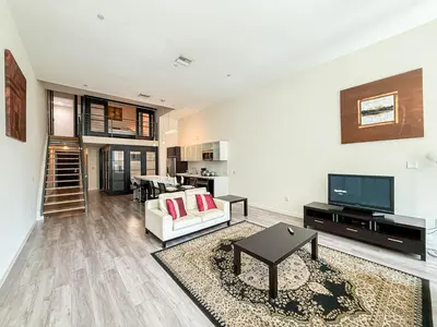 a living room with a couch and a tv at Relax and recharge in this elegant 2BR loft - 108 - GL in Glendale