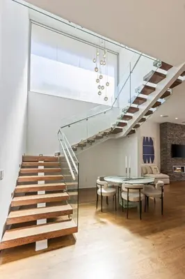 a glass staircase in a room with a table and chairs at 5BR Modern West Hollywood Retreat in Los Angeles