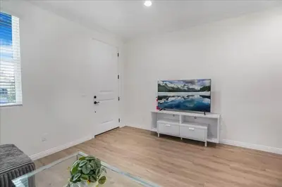 a living room with a tv on a white wall at Newly Built Pasadena Retreat Parking Great Location in Pasadena