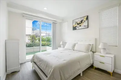 a white bedroom with a large bed and a window at Newly Built Pasadena Retreat Parking Great Location in Pasadena
