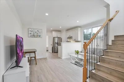 a living room with a staircase and a kitchen at Stylish Pasadena Stay Near Old Town & Rose Bowl in Pasadena