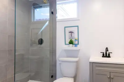 a bathroom with a shower and a toilet and a sink at Modern Private Guesthouse with Parking, Yard, and Washer Dryer in Inglewood