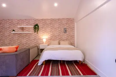 a bedroom with a bed and a brick wall at Modern Private Guesthouse with Parking, Yard, and Washer Dryer in Inglewood