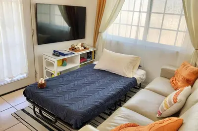a living room with a bed and a couch at 8670 San Carlos - South Gate CA - The Best 2 Rooms in South Gate