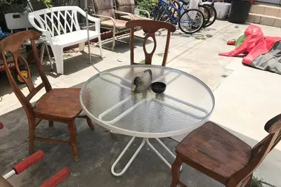 a bird sitting on a glass table with two chairs at 8670 San Carlos - South Gate CA - The Best 2 Rooms in South Gate