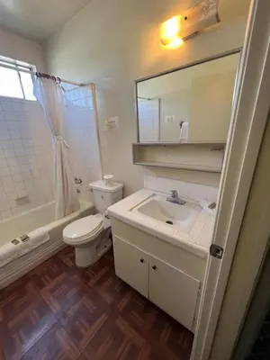 a bathroom with a sink and a toilet and a mirror at York Motel in Los Angeles