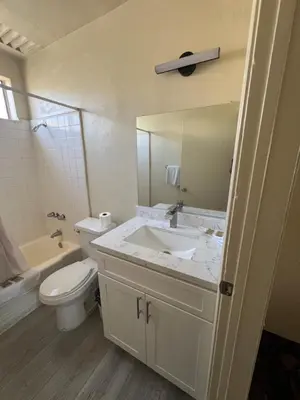 a bathroom with a sink and a toilet and a mirror at York Motel in Los Angeles