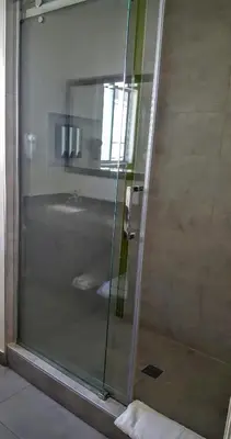 a shower with a glass door in a bathroom at Jewel City Inn in Glendale