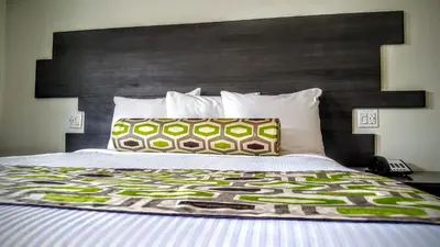 a bedroom with a large bed with a black headboard at Jewel City Inn in Glendale