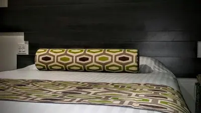 a bed with a pillow sitting on top of it at Jewel City Inn in Glendale