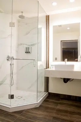 a bathroom with a shower and a sink at Hotel Xilo Glendale in Glendale