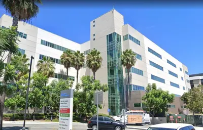 a large white building with palm trees in front of it at Two bedroom private guesthouse in great location Close to Melrose Hollywood sign and attractions in Los Angeles