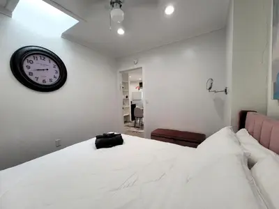 a bedroom with a bed with a clock on the wall at Two bedroom private guesthouse in great location Close to Melrose Hollywood sign and attractions in Los Angeles