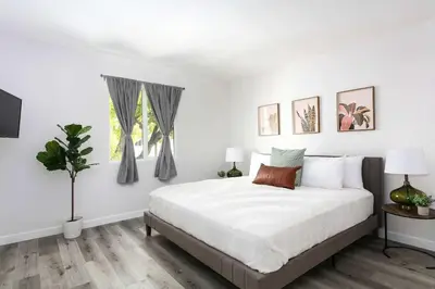 a white bedroom with a bed and a window at Luxury 2BR Apartment Great Area with Parking in Glendale