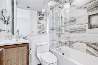 a white bathroom with a toilet and a shower at Modern 4BR Villa Spacious Stylish In Prime Location in Los Angeles