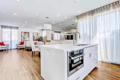 a kitchen with a white counter top and a living room at Modern 4BR Villa Spacious Stylish In Prime Location in Los Angeles