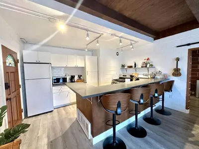 an open kitchen with white appliances and bar stools at Ocean View Balcony, 4 Min Walk to Beach in Manhattan Beach