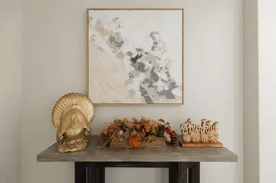 a table with a painting and some statues on it at The Reel Deal, Luxury Family Cabin by Alpine Slide in Big Bear Lake
