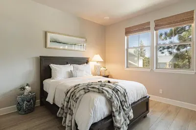 a bedroom with a large bed and two windows at The Reel Deal, Luxury Family Cabin by Alpine Slide in Big Bear Lake